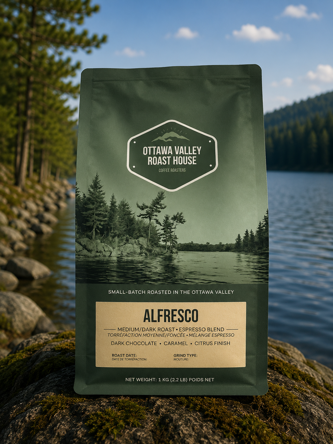 A bag of Ottawa Valley Roast House Alfresco coffee stands upright on a rock with a forest and lake landscape in the background. The package is dark green with a beige label panel and printed forest imagery.