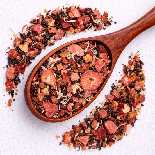 Wooden spoon filled with a mix of dried fruits and herbs on a white background