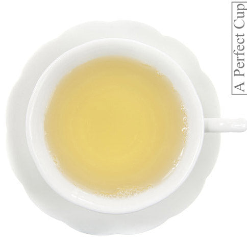 White teacup with yellow liquid on a white background