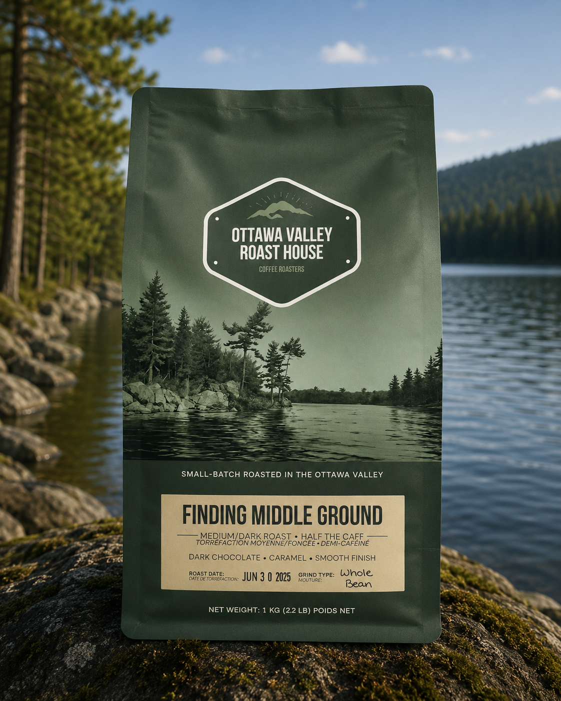 A bag of Ottawa Valley Roast House 'Finding Middle Ground' coffee stands upright on a mossy rock with a lake, pine trees, and mountains in the background.