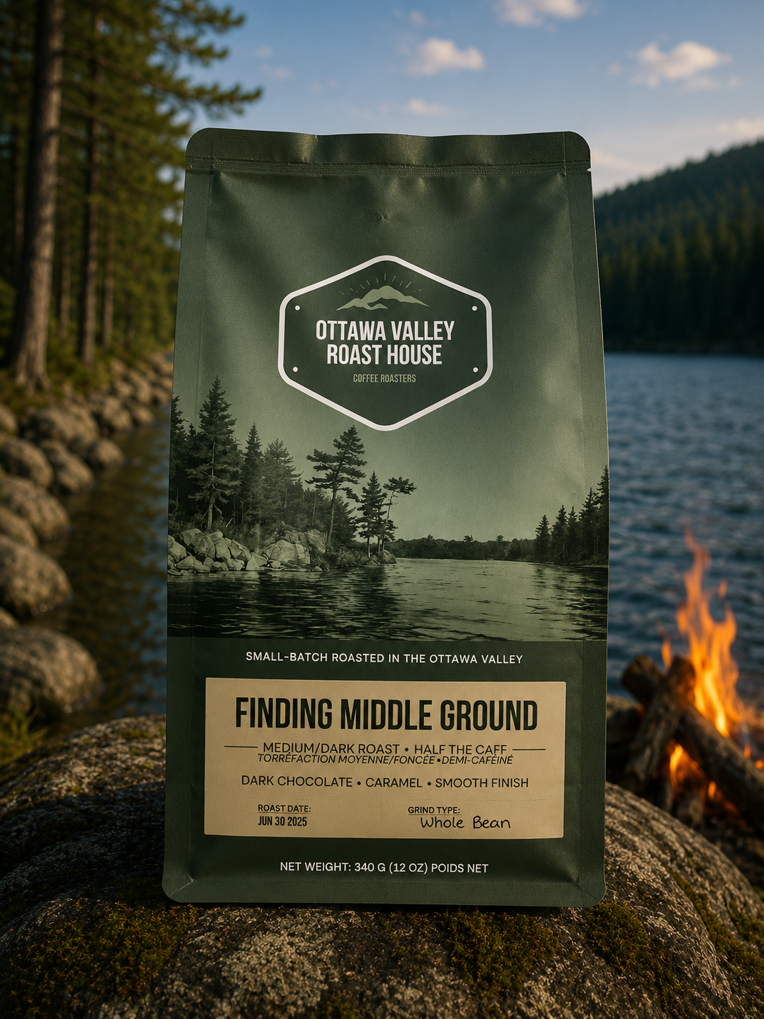 A bag of Ottawa Valley Roast House coffee stands upright on a rock outdoors, with a lake, forest, and campfire visible in the blurred background. The package is dark olive green with white and beige text blocks and a scenic lake-and-trees label on the front.