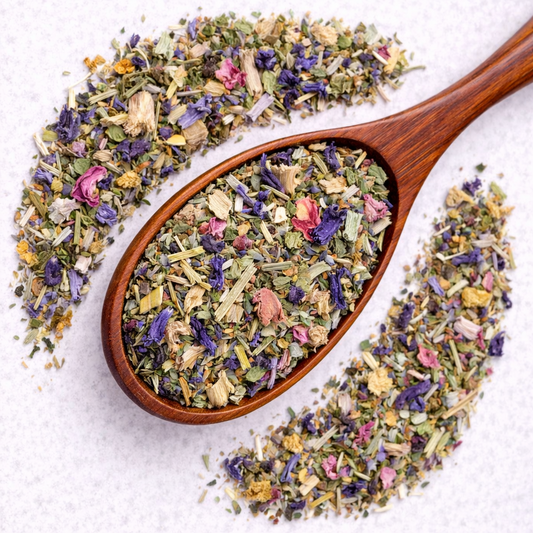 Wooden spoon filled with a mix of dried herbs and flowers on a light background