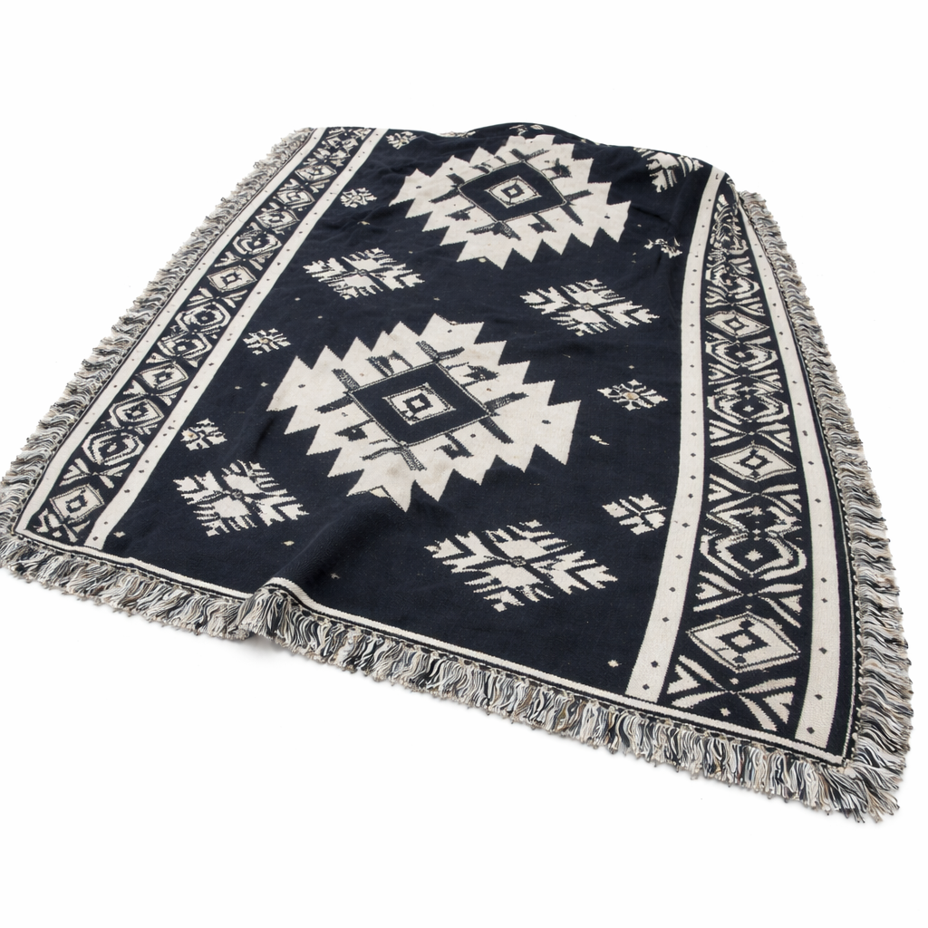 Navy blue and white patterned blanket with fringes on a white background