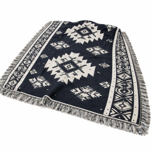 Navy blue and white patterned blanket with fringes on a white background