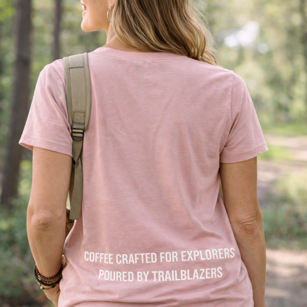 Person wearing a pink t-shirt with text in a forest setting